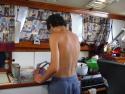 Tim washing dishes in the a.m. Hot weather forces curtains closed and shirt off!